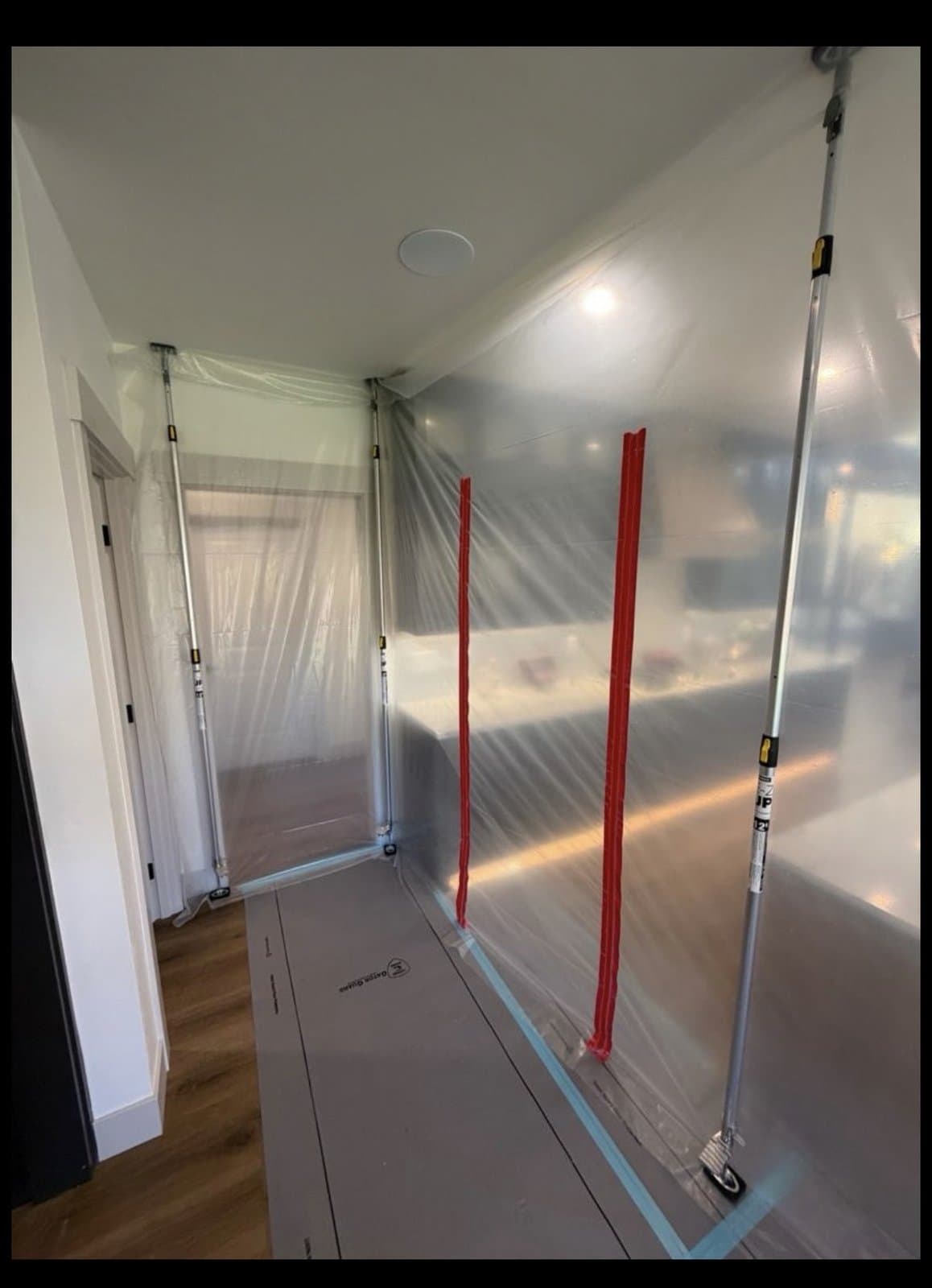 Hallway with plastic containment barrier during restoration