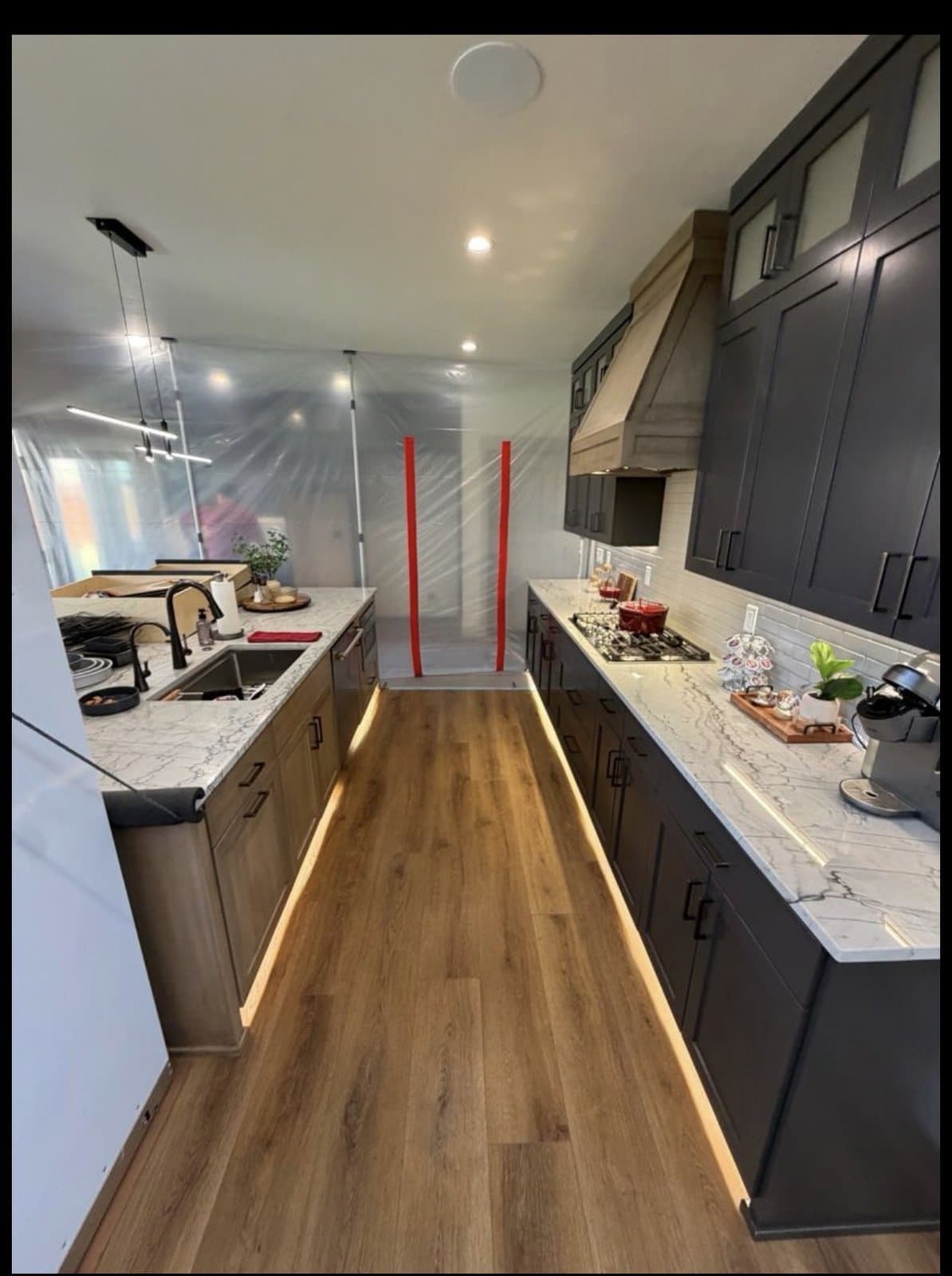 Kitchen mid-renovation with containment barriers and finished cabinetry