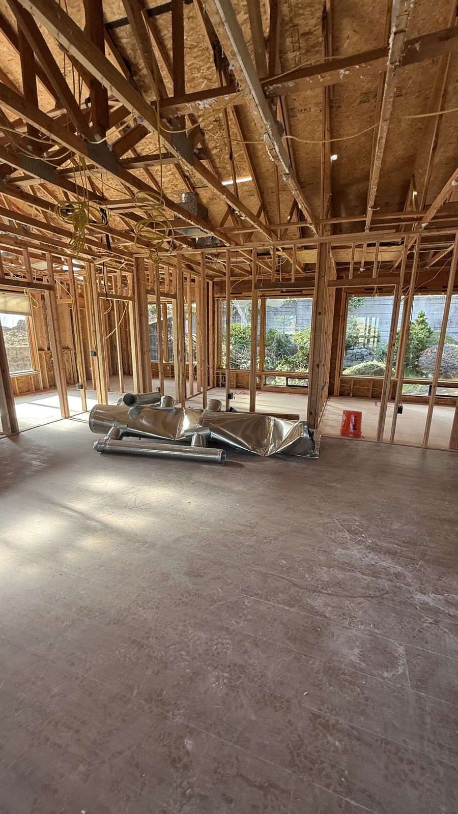 Gutted room with exposed ceiling framing and ductwork